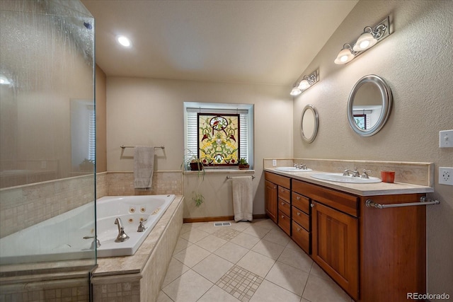 bathroom with double sink vanity, tiled tub, and tile patterned flooring