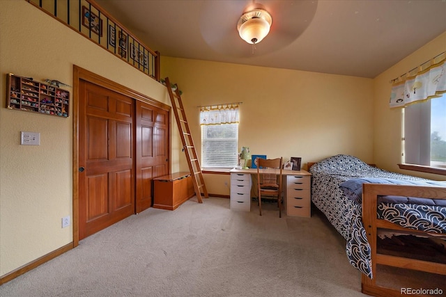 bedroom featuring ceiling fan, multiple windows, and light colored carpet