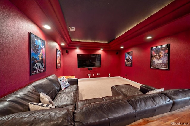 home theater room featuring carpet flooring and a raised ceiling