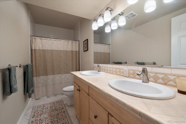 bathroom with double sink vanity, toilet, tile patterned flooring, and backsplash