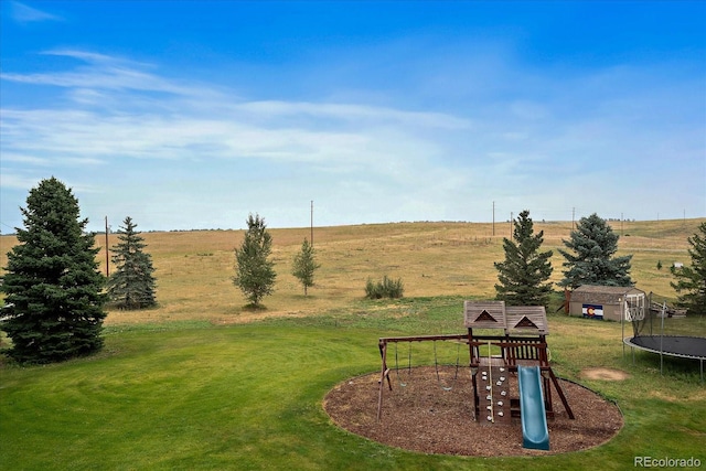 view of yard with a rural view, a playground, a trampoline, and a shed