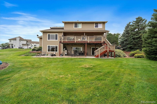 back of house featuring a wooden deck, a patio area, and a yard