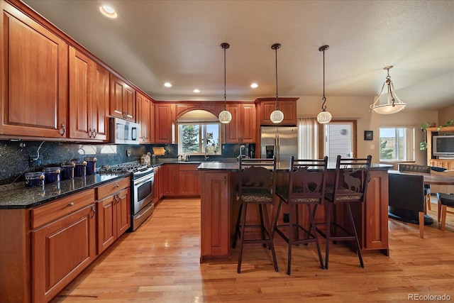 5861 E Valley Hi Dr, Parker, CO 80138 - kitchen featuring stainless steel appliances, light wood-style floors, a breakfast bar, recessed lighting, and backsplash