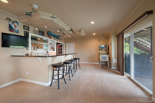 5861 E Valley Hi Dr, Parker, CO 80138 - kitchen featuring light colored carpet, crown molding, recessed lighting, a breakfast bar, and dark countertops