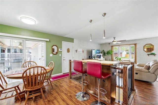 kitchen with butcher block counters, wood finished floors, baseboards, ceiling fan, and decorative light fixtures