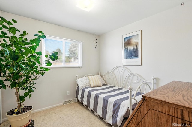 bedroom featuring baseboards, visible vents, and light carpet