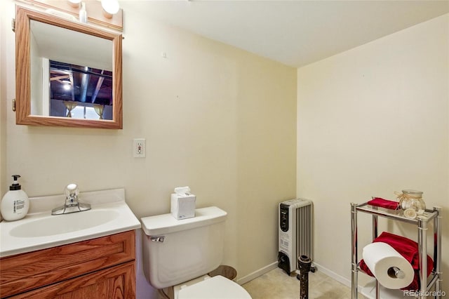 bathroom featuring vanity, baseboards, tile patterned flooring, and toilet
