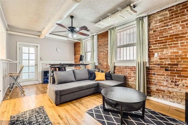 1376 N Pearl St Unit B1, Denver, CO 80203 - living room featuring a textured ceiling, a healthy amount of sunlight, brick wall, ceiling fan, and hardwood / wood-style floors