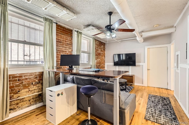 1376 N Pearl St Unit B1, Denver, CO 80203 - living room featuring light wood-style flooring, a textured ceiling, a ceiling fan, and brick wall