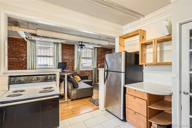 1376 N Pearl St Unit B1, Denver, CO 80203 - kitchen with electric stove, freestanding refrigerator, brick wall, open shelves, and light tile patterned floors