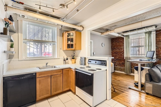 1376 N Pearl St Unit B1, Denver, CO 80203 - kitchen with light countertops, dishwasher, a sink, white electric range oven, and brick wall
