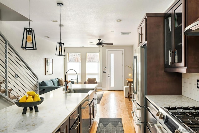 1581 Wolff St, Denver, CO 80204 - kitchen with a sink, stainless steel appliances, light wood-type flooring, open floor plan, and glass insert cabinets