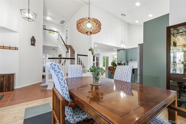 1540 Meachum Way, Erie, CO 80516 - dining space with high vaulted ceiling, stairs, recessed lighting, baseboards, and light wood finished floors