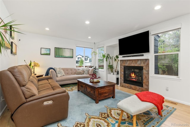 1540 Meachum Way, Erie, CO 80516 - living area with plenty of natural light, a tiled fireplace, recessed lighting, wood finished floors, and baseboards