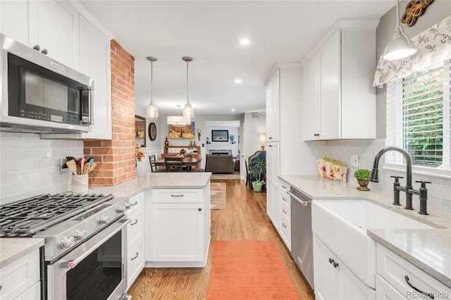 3317 Harlan St, Wheat Ridge, CO 80033 - kitchen featuring appliances with stainless steel finishes, a sink, light wood-style floors, white cabinets, and recessed lighting