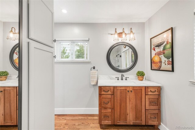 3317 Harlan St, Wheat Ridge, CO 80033 - bathroom with vanity, baseboards, and wood finished floors