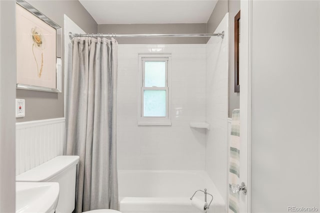 3317 Harlan St, Wheat Ridge, CO 80033 - bathroom featuring toilet, shower / tub combo with curtain, and a wainscoted wall