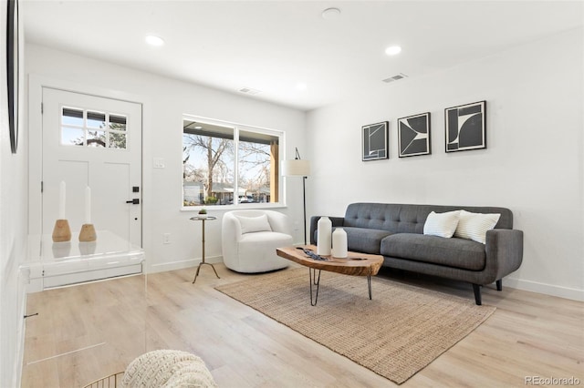 living area with recessed lighting, visible vents, baseboards, and wood finished floors