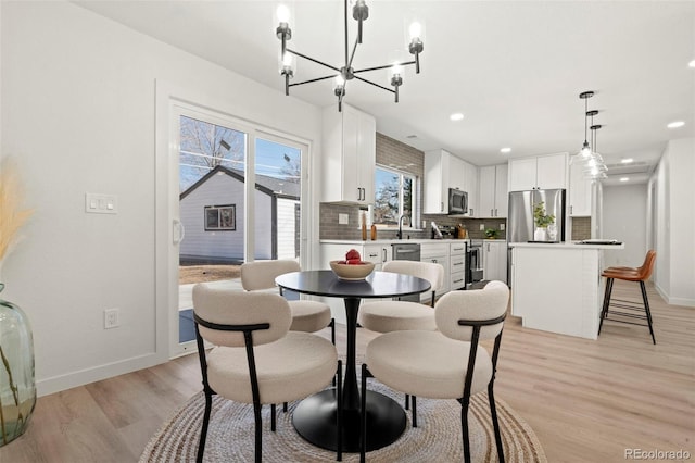 dining space featuring an inviting chandelier, recessed lighting, baseboards, and light wood-type flooring