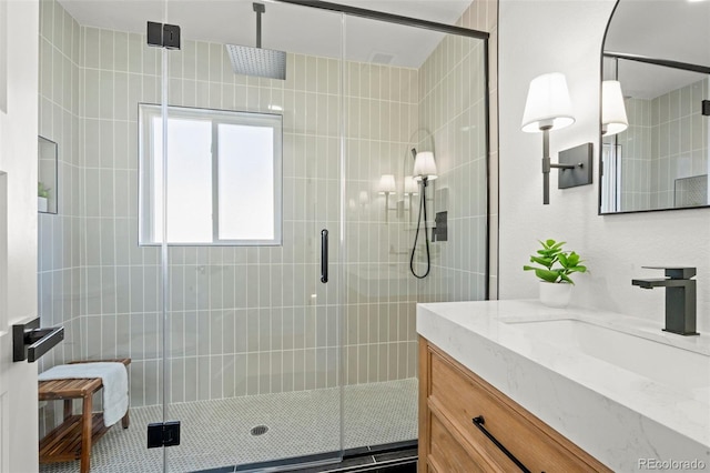 full bath with vanity and a shower stall