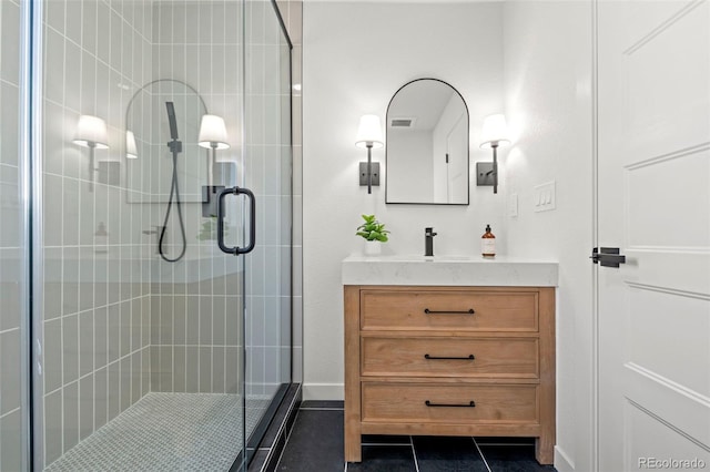 full bathroom featuring tile patterned flooring, a stall shower, and vanity