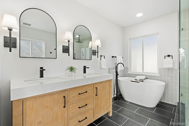 bathroom featuring a sink, visible vents, double vanity, and tile patterned flooring