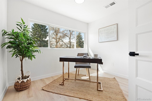 home office featuring visible vents, baseboards, and wood finished floors