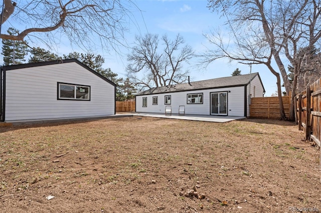 rear view of house featuring a patio area, a yard, and a fenced backyard