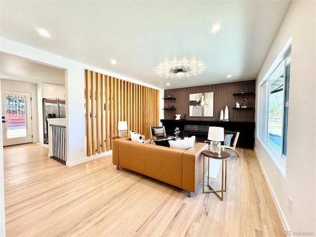 living room featuring baseboards, light wood finished floors, and recessed lighting