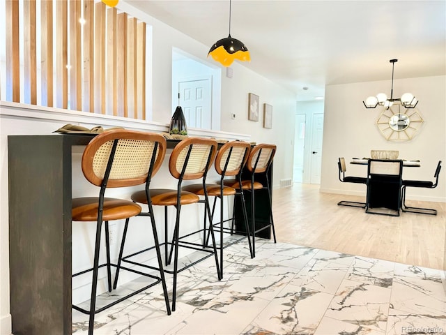 bar featuring marble finish floor, visible vents, a bar, a chandelier, and baseboards