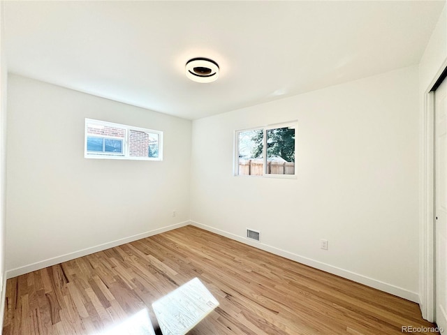 unfurnished bedroom with light wood-style flooring, a closet, visible vents, and baseboards