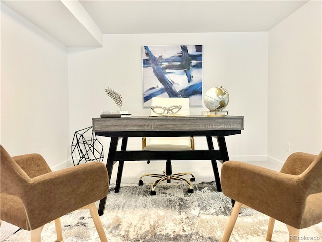 office area featuring light carpet and baseboards