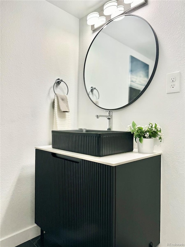 bathroom with a chandelier, vanity, and baseboards