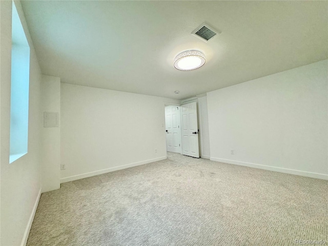 unfurnished bedroom featuring baseboards, visible vents, and light colored carpet