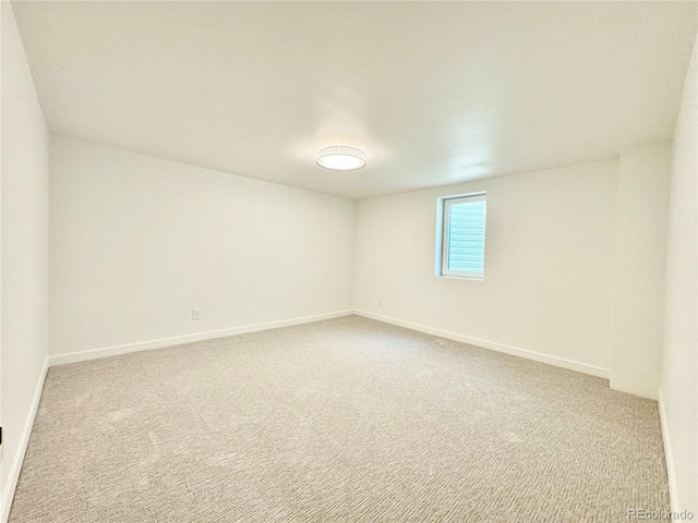 carpeted spare room featuring baseboards