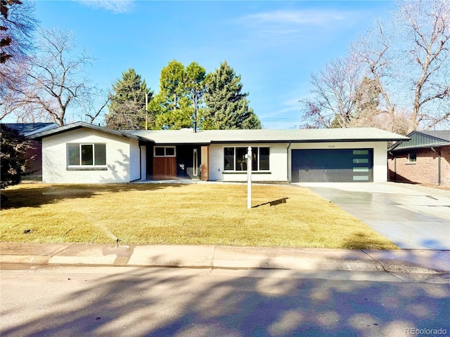 single story home with an attached garage, a front yard, and concrete driveway