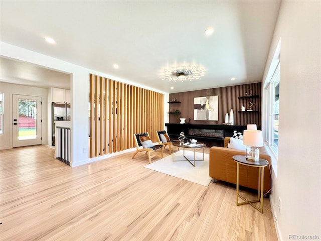 living area featuring baseboards, wood finished floors, and recessed lighting