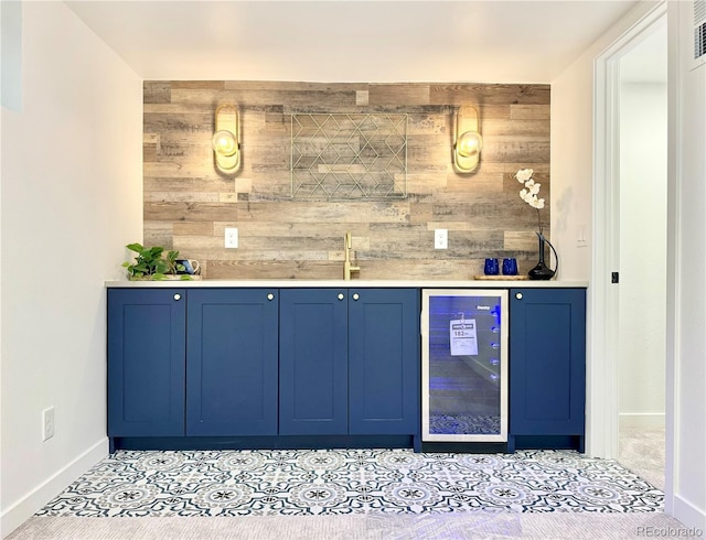 bar featuring baseboards, wood walls, beverage cooler, and wet bar