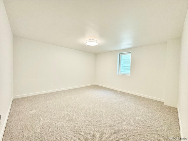 carpeted empty room featuring baseboards