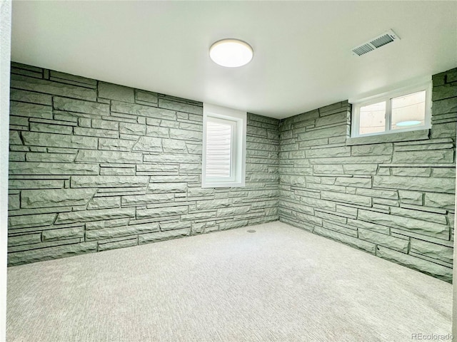 below grade area with a healthy amount of sunlight, visible vents, and carpet