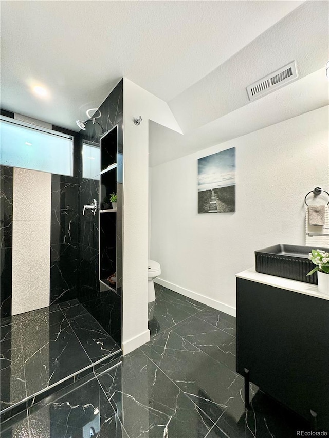 bathroom with a marble finish shower, toilet, baseboards, visible vents, and marble finish floor