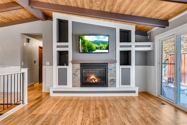 unfurnished living room with light wood-type flooring, lofted ceiling with beams, a fireplace, and wood ceiling