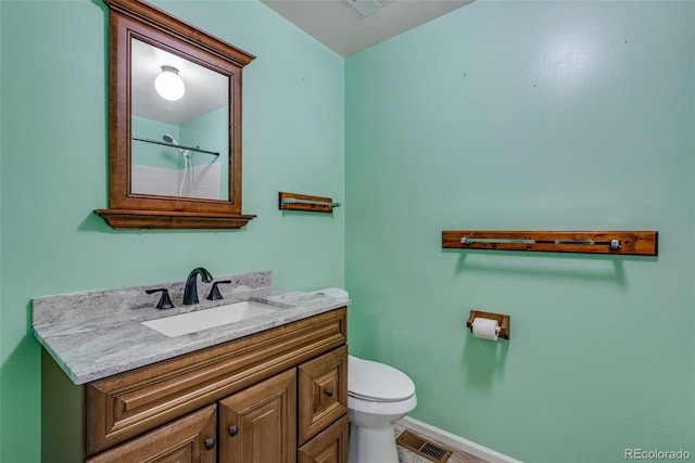 bathroom featuring vanity, toilet, and a shower