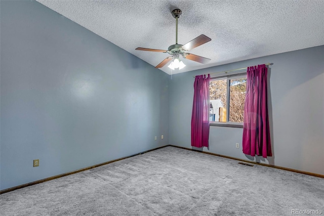 carpeted spare room with a textured ceiling, ceiling fan, and lofted ceiling