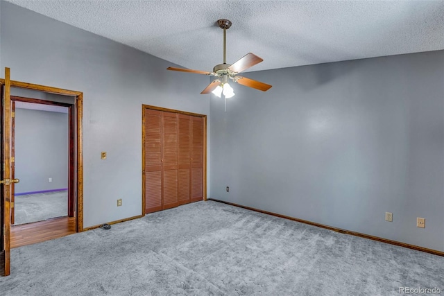 unfurnished bedroom featuring light carpet, a textured ceiling, and ceiling fan