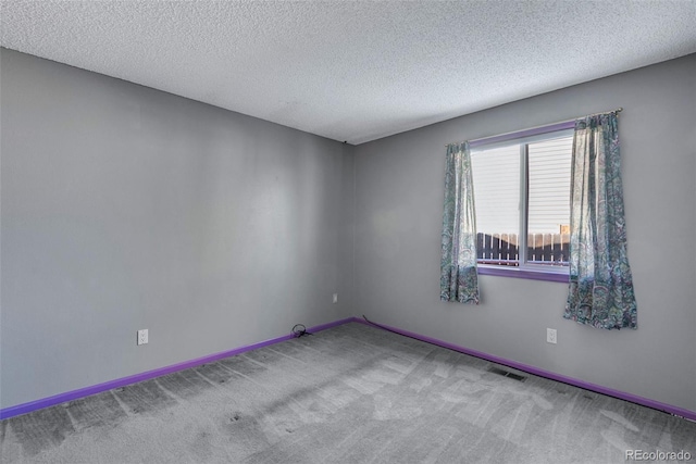 carpeted spare room featuring a textured ceiling