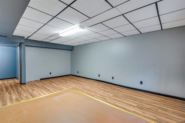 basement with a paneled ceiling and wood-type flooring