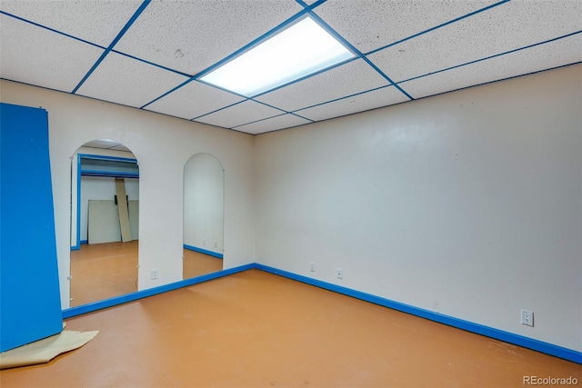 unfurnished room featuring a drop ceiling