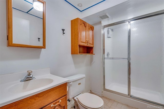 bathroom with vanity, toilet, and a shower with door