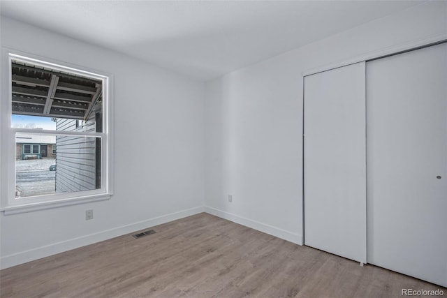 unfurnished bedroom featuring light hardwood / wood-style flooring and a closet